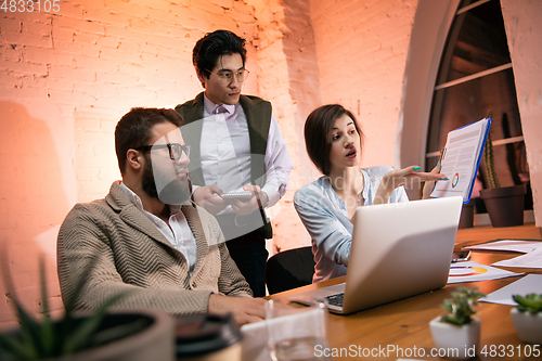 Image of Colleagues working together in modern office using devices and gadgets during creative meeting