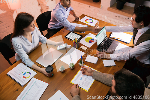 Image of Colleagues working together in modern office using devices and gadgets during creative meeting