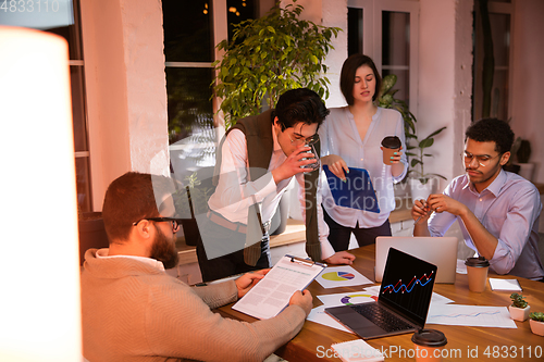 Image of Colleagues working together in modern office using devices and gadgets during creative meeting