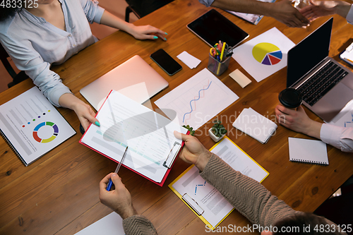 Image of Colleagues working together in modern office using devices and gadgets during creative meeting