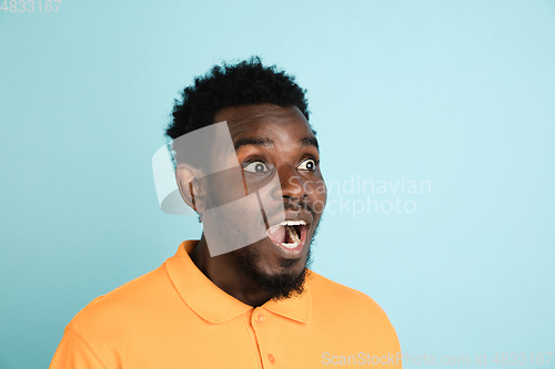 Image of African man\'s portrait isolated over blue studio background with copyspace