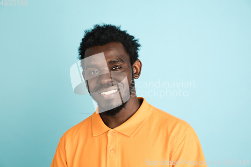 Image of African man\'s portrait isolated over blue studio background with copyspace