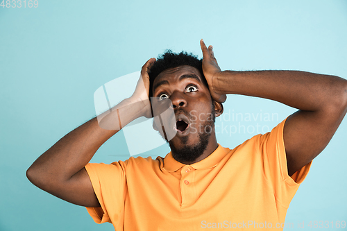 Image of African man\'s portrait isolated over blue studio background with copyspace