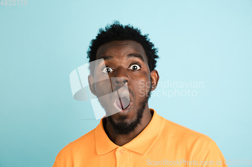 Image of African man\'s portrait isolated over blue studio background with copyspace