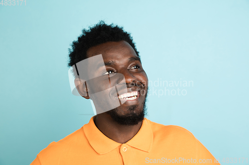 Image of African man\'s portrait isolated over blue studio background with copyspace
