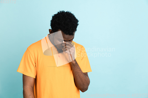 Image of African man\'s portrait isolated over blue studio background with copyspace