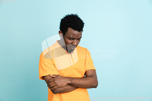 Image of African man\'s portrait isolated over blue studio background with copyspace
