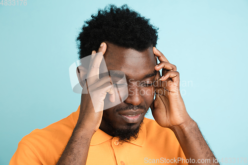 Image of African man\'s portrait isolated over blue studio background with copyspace