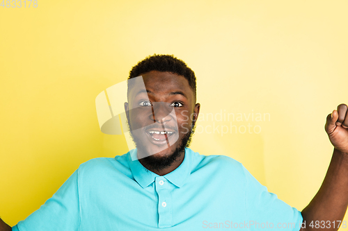 Image of Portrait of young African man isolated over yellow studio background with copyspace.