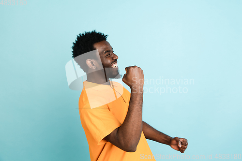 Image of African man\'s portrait isolated over blue studio background with copyspace