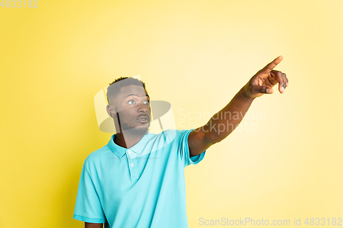 Image of Portrait of young African man isolated over yellow studio background with copyspace.