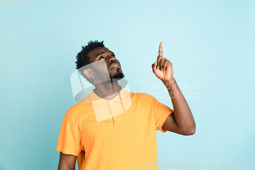 Image of African man\'s portrait isolated over blue studio background with copyspace