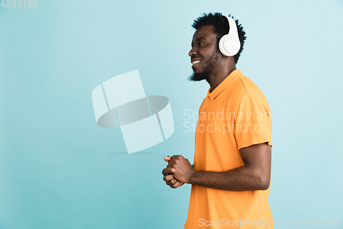 Image of African man\'s portrait isolated over blue studio background with copyspace