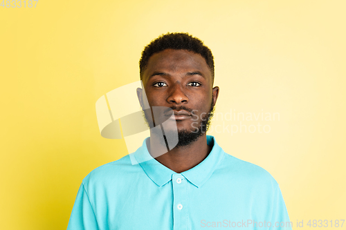 Image of Portrait of young African man isolated over yellow studio background with copyspace.