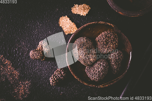 Image of Black truffle in bowl on dark background