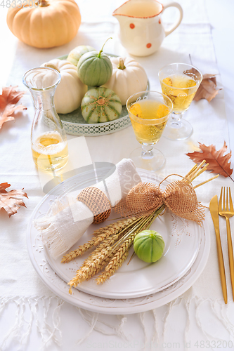 Image of Place settings for Thanksgiving with pumpkins and apple wine