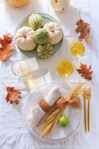 Image of Place settings for Thanksgiving with pumpkins and apple wine