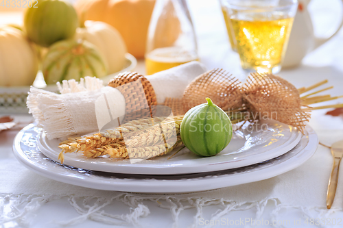 Image of Place settings for Thanksgiving with pumpkins and apple wine