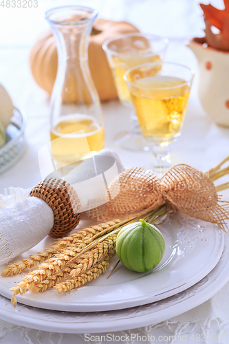 Image of Place settings for Thanksgiving with pumpkins and apple wine