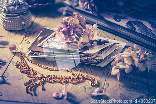 Image of Memories - old family photo album with necklace, old books and dried flowers