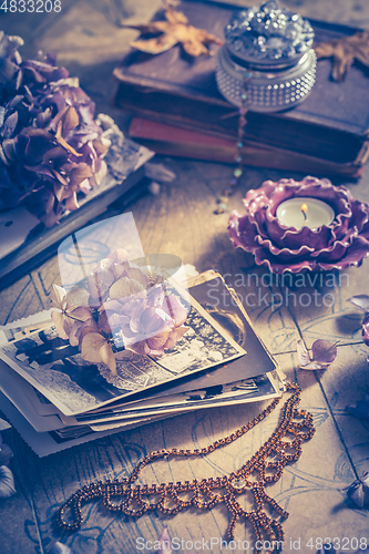 Image of Memories - old family photo album with necklace, old books and dried flowers