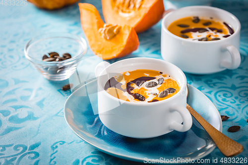 Image of Homemade pumpkin soup with coconut milk, pumpkin oil and seeds