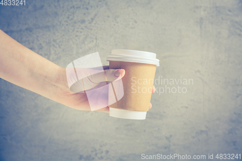 Image of Hand holding disposable coffee cup