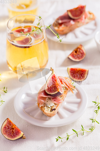Image of Small canape snack, crostini with ham, fig and apple wine