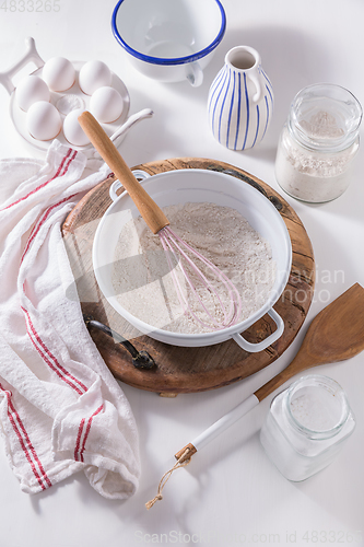 Image of Flour and egg with baking ingredients and kitchen utensils