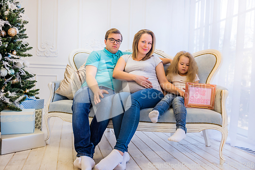 Image of Family portrait near christmas tree. Pregnant woman