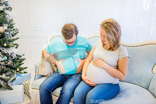 Image of Family portrait near christmas tree. Pregnant woman