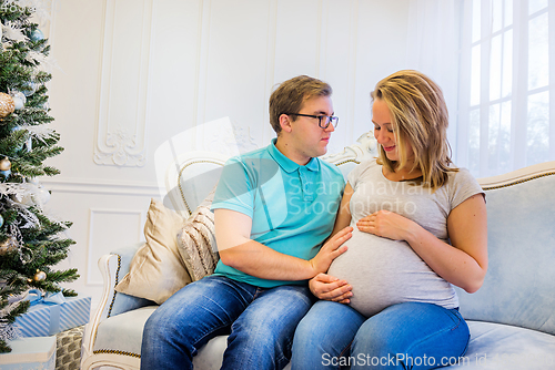 Image of Family portrait near christmas tree. Pregnant woman