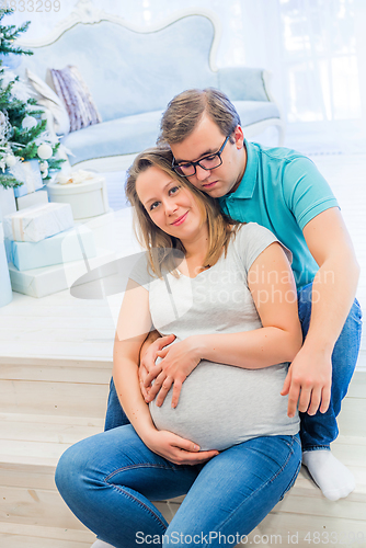 Image of Family portrait near christmas tree. People sitting on the staircase