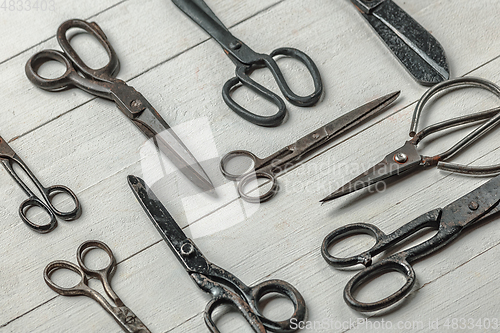 Image of Vintage steel scissors on wooden table background