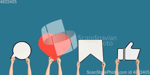 Image of Hands holding the signs of social media on blue studio background, flyer