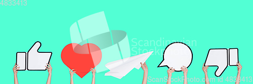 Image of Hands holding the signs of social media on turquoise studio background, flyer