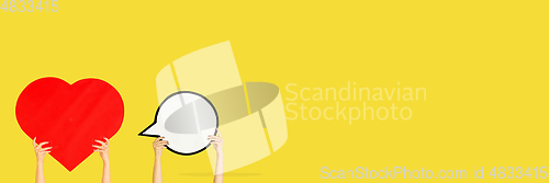 Image of Hands holding the signs of social media on yellow studio background, flyer