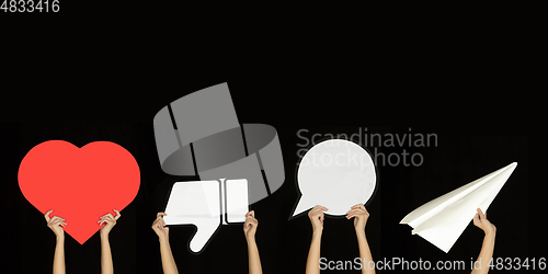 Image of Hands holding the signs of social media on black studio background, flyer