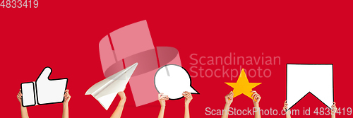 Image of Hands holding the signs of social media on red studio background, flyer