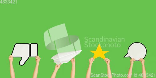 Image of Hands holding the signs of social media on green studio background, flyer