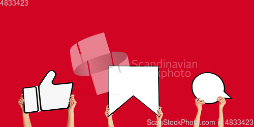 Image of Hands holding the signs of social media on red studio background, flyer