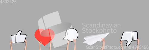 Image of Hands holding the signs of social media on grey studio background, flyer
