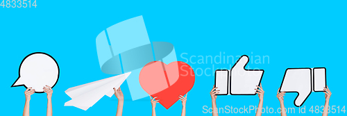 Image of Hands holding the signs of social media on blue studio background, flyer