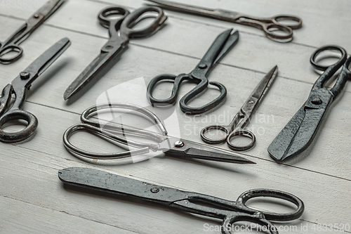 Image of Vintage steel scissors on wooden table background