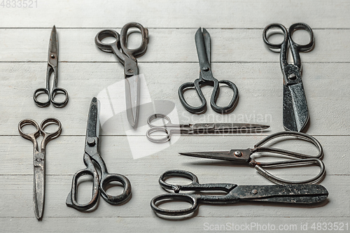 Image of Vintage steel scissors on wooden table background