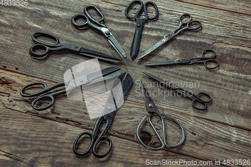 Image of Vintage steel scissors on wooden table background