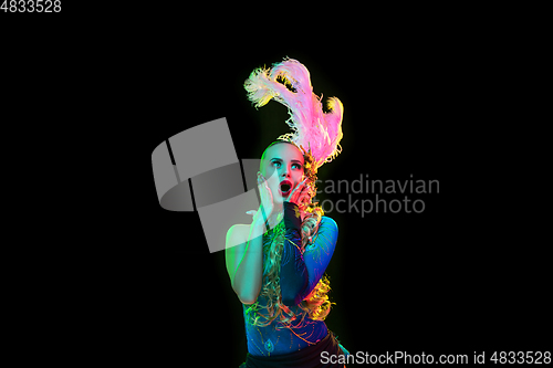 Image of Beautiful young woman in carnival and masquerade costume in colorful neon lights on black background