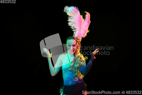 Image of Beautiful young woman in carnival and masquerade costume in colorful neon lights on black background