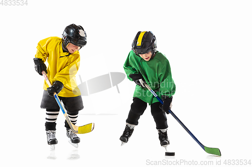 Image of Little hockey players with the sticks on ice court and white studio background