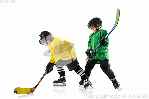 Image of Little hockey players with the sticks on ice court and white studio background